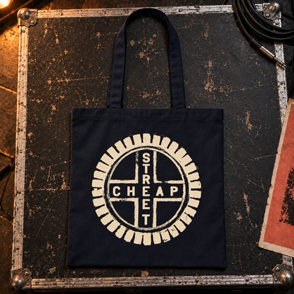 Cheap Street logo tote bag with a large warm cream Cheap Street emblem on the front, laid on a flight case