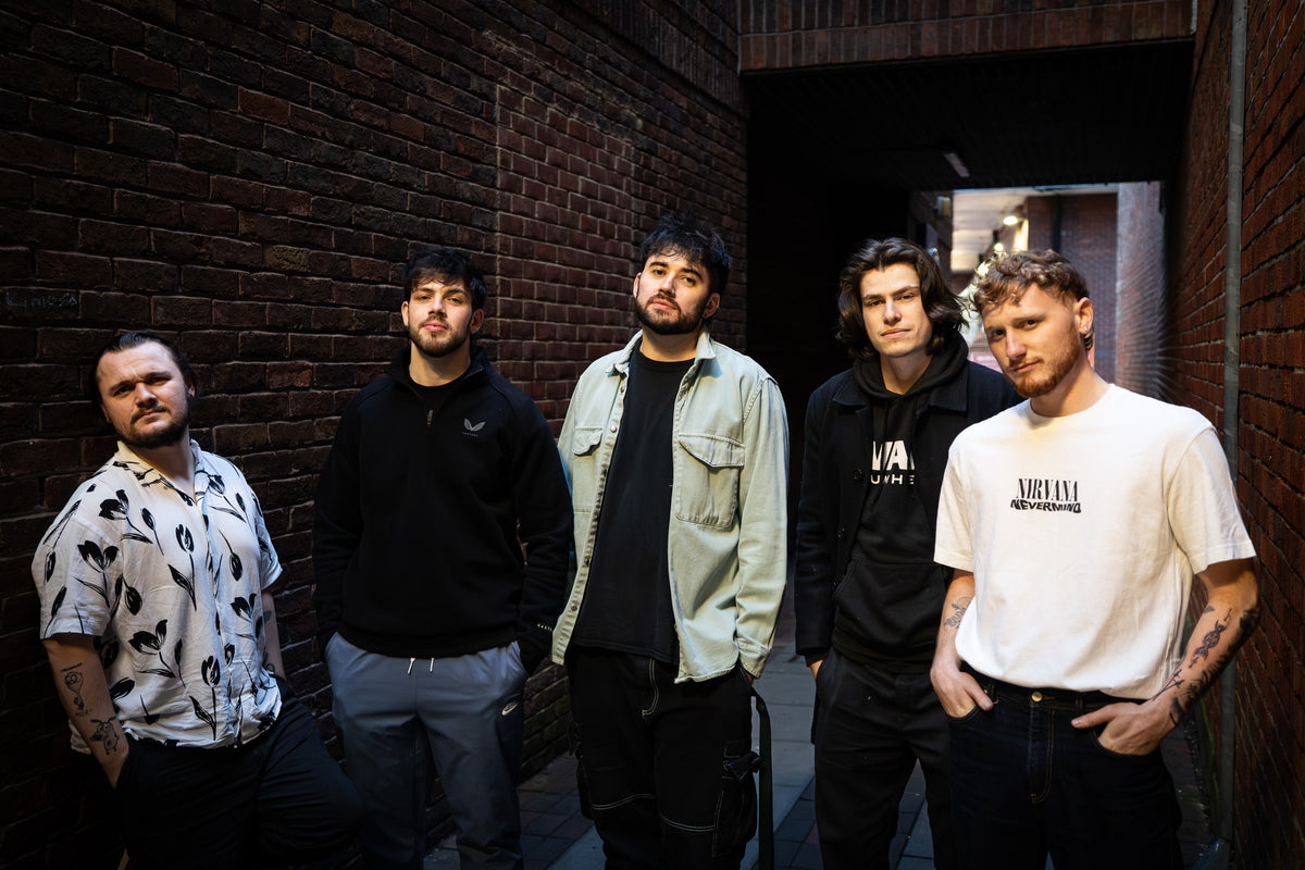 The five members of ear candy standing in a brick alleyway