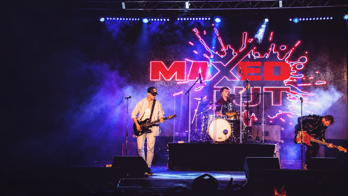 Maxed Out on stage: a guitarist, a drummer and a bassist in front of the band's red neon logo, under purple and blue lights
