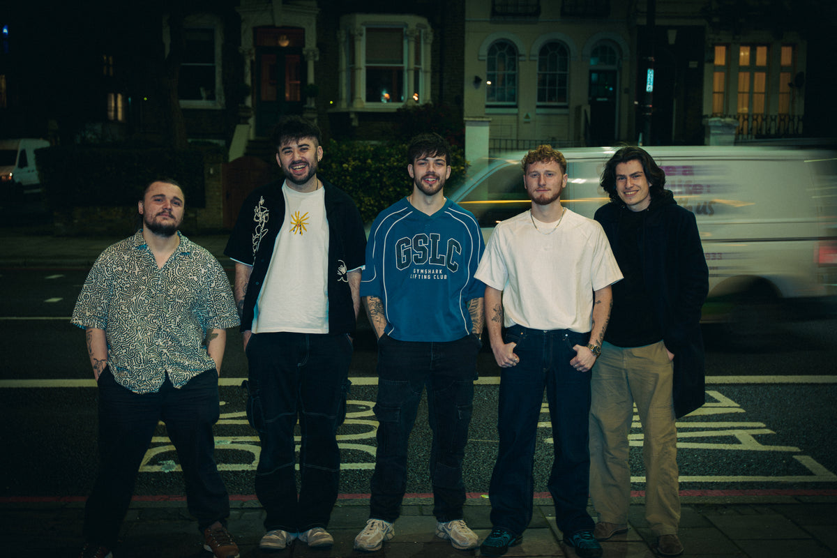 The five members of ear candy standing in a row on a city street at night