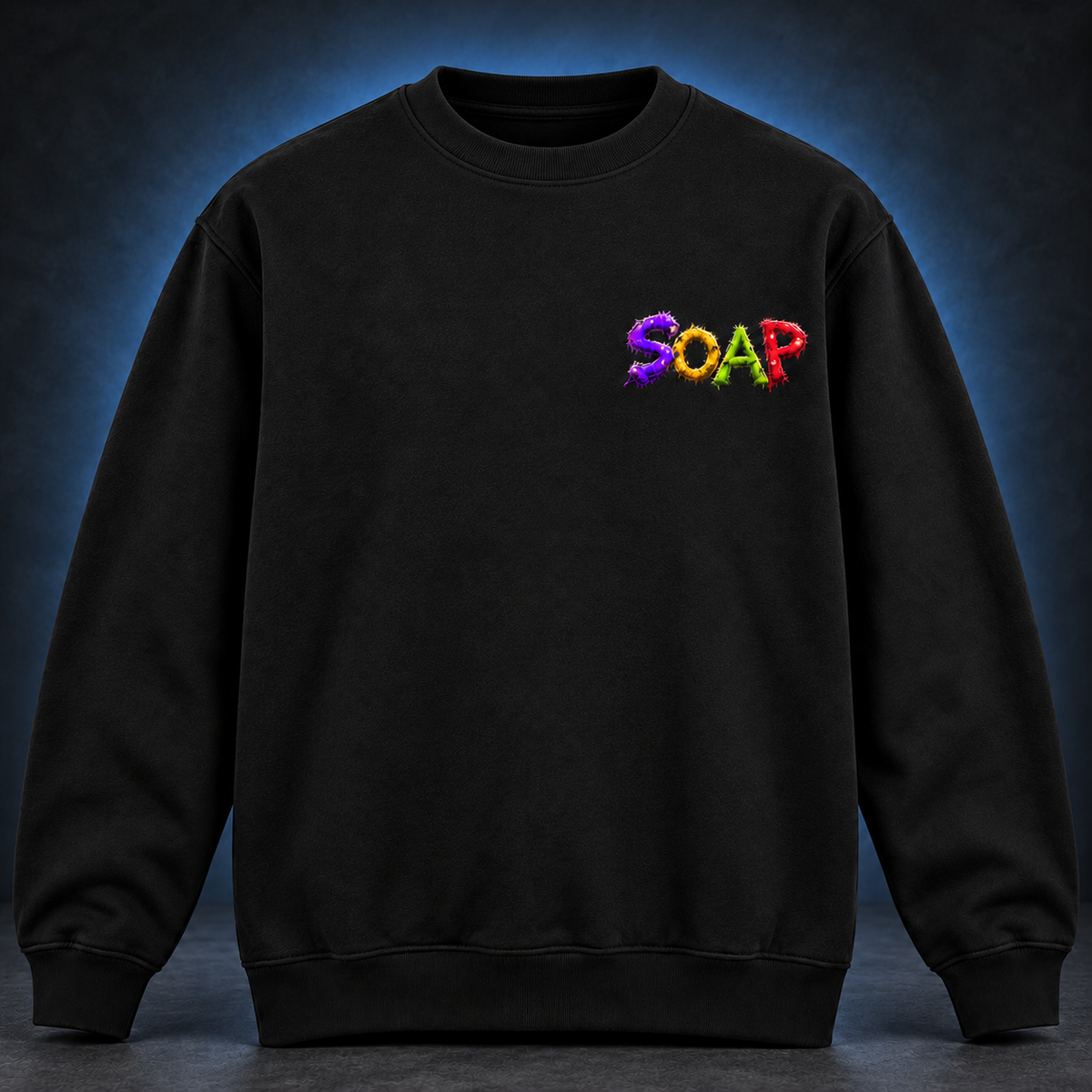 Front of a black crew-neck sweatshirt with a small SOAP wordmark in purple, yellow, green and red on the chest