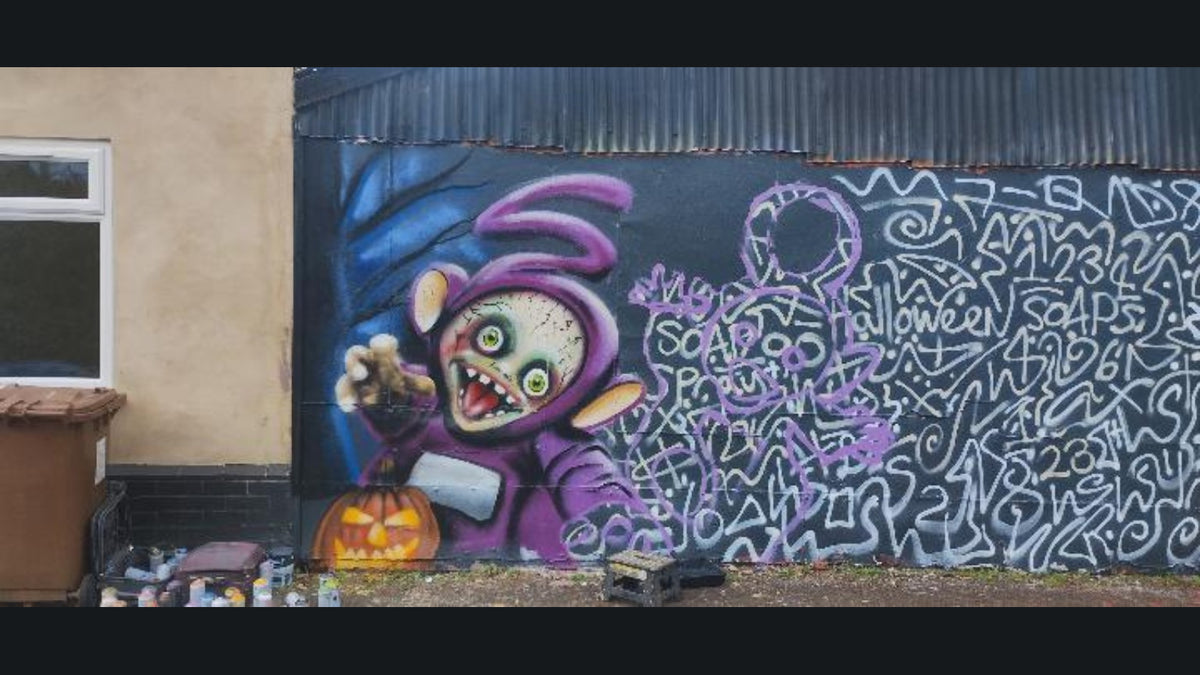SOAP's Halloween mural in progress: the purple S character is painted, with the other figures outlined and spray cans on the ground