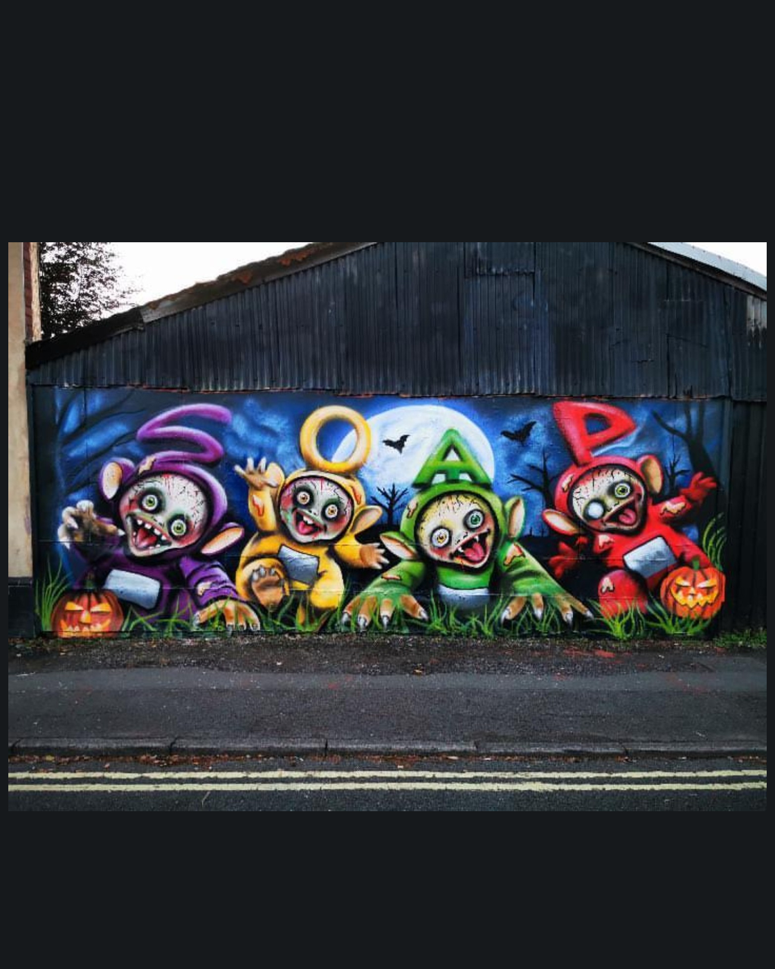 SOAP's finished Halloween mural: four purple, yellow, green and red characters beneath the letters S O A P, painted on a corrugated wall